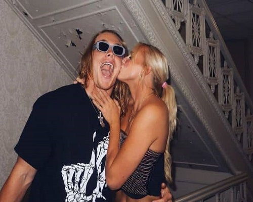 Carson Steele's partner kissing him